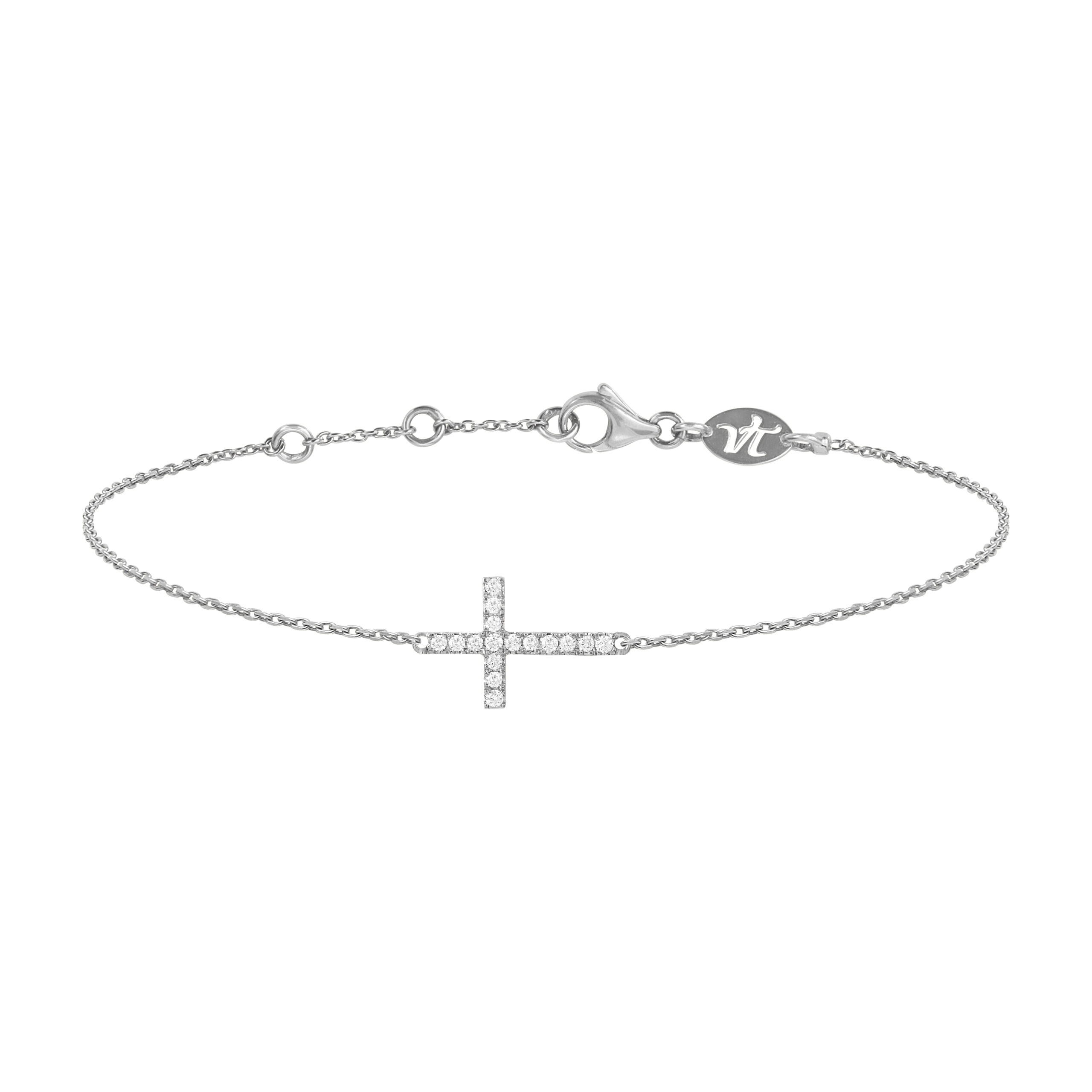 Bracelet croix en or blanc et diamants pour femme, à superposer ou à accumuler. Ce bijou de joaillerie fine porté par Meghan Markle et made in France est prisé par les stars et célébrités et est idéal en cadeau d'anniversaire, d'amitié ou d'amour.